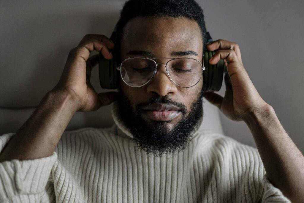 A man wearing headphones and closing his eyes doing a visualisation