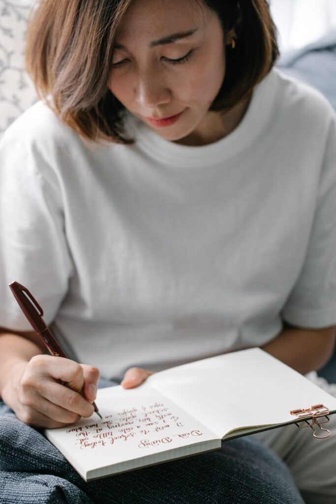 A woman writing goals in her journal